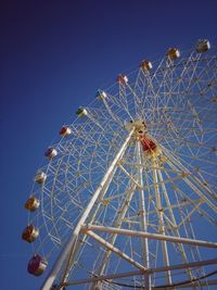 Low angle view of ferris wheel against clear blue sky