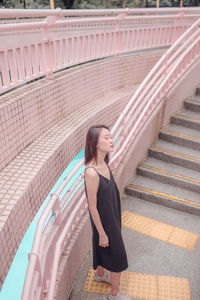 Woman standing against railing