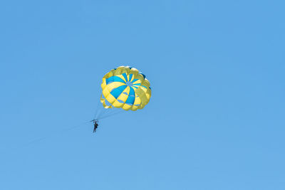 Low angle view of kite flying against clear blue sky