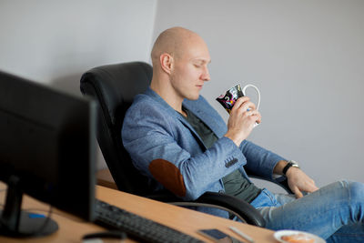 Businessman having coffee at desk in office