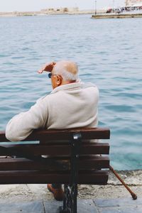 Rear view of man sitting on bench