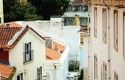 People sitting on house roof in city