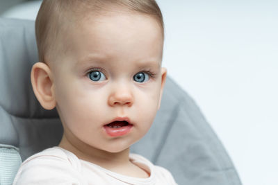 Close-up of cute baby boy against white background