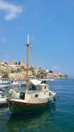 Boats moored at harbor against sky