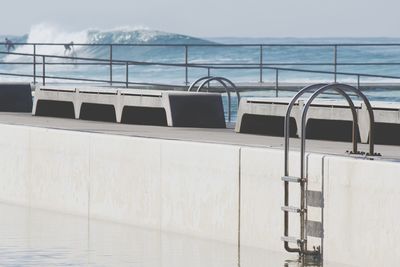 Wall by swimming pool against sky