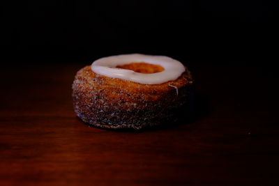 Close-up of cake on table against black background