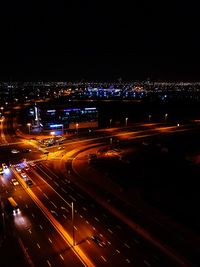 Light trails on road in city against sky at night