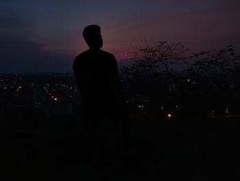 Silhouette man standing against sky at night