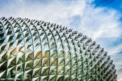 Low angle view of modern building against cloudy sky