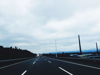 Empty road against cloudy sky