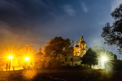 Low angle view of illuminated buildings against sky at night