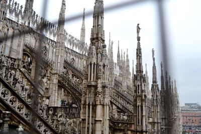 Low angle view of milan cathedral seen through metal grate