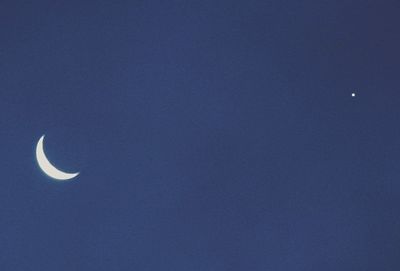 Low angle view of moon in blue sky