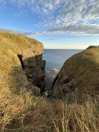 Rocks on sea shore against sky