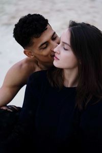 Close-up of young couple  looking away against sky