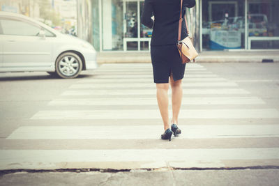 Low section of man walking on road