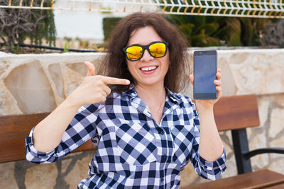 Portrait of smiling young woman using mobile phone