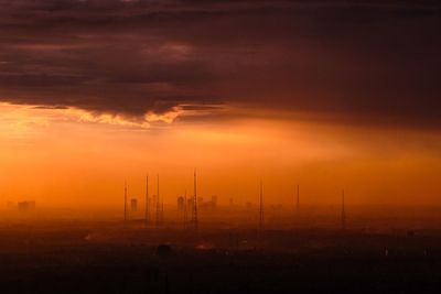 Silhouette of landscape against cloudy sky during sunset