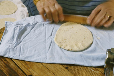 Cropped image of woman preparing dough at home