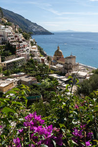Scenic view of sea by buildings in town against sky