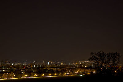 Illuminated cityscape against sky at night