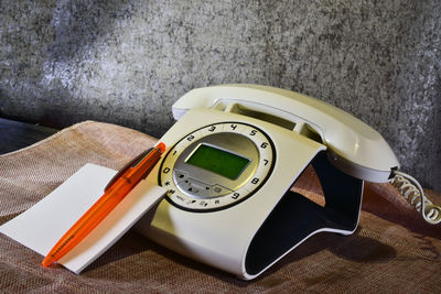 Close-up of book and pen by telephone on table