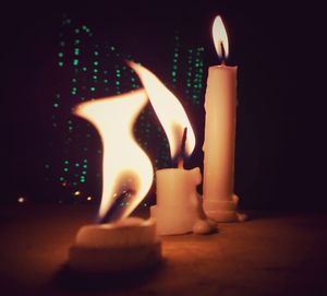 Close-up of lit candle against black background