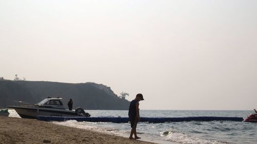 People on beach against clear sky