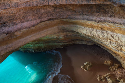 Benagil wild hidden secret cave beach top view above with turquoise water in carvoeiro, portugal