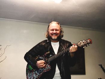 Portrait of a smiling young man playing guitar