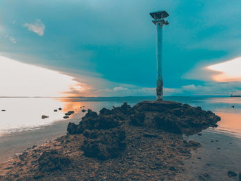 Close-up of rock on beach against sky at sunset