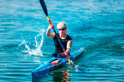 Young woman kayaking on lake