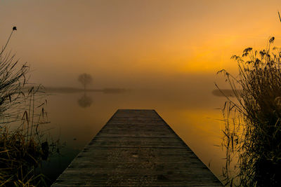 Scenic view of lake against orange sky