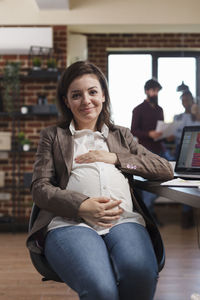 Portrait of young woman using laptop while sitting at home