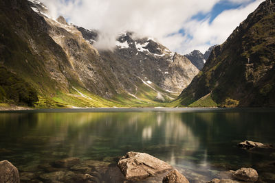 Scenic view of lake and snowcapped mountains against sky