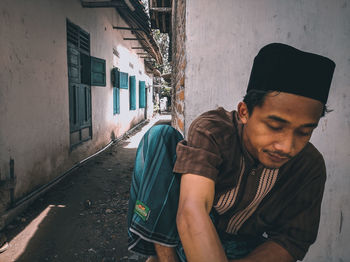 Young man standing on street against building in city