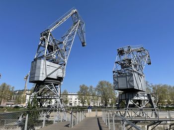 Low angle view of crane against clear blue sky