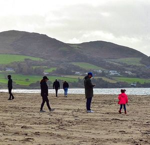 People at beach against sky