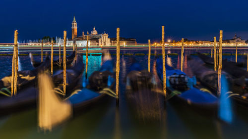 View of boats moored in canal at night