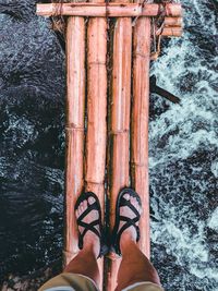 Low section of man standing on pier over sea