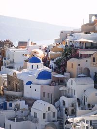 A hillside town in santorini, with traditional greek whitewashed buildings and blue roofs. 