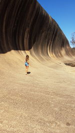 Full length of woman standing by rock formation