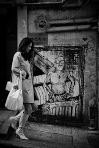 Rear view of women standing against wall