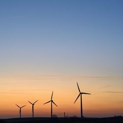 Wind turbine against sky during sunset