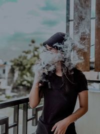 Midsection of man smoking cigarette