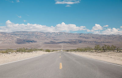 Road amidst desert against sky