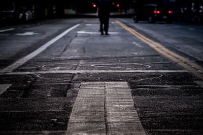 Low section of person walking on street at dusk