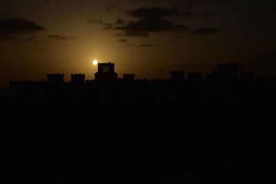 Silhouette buildings against sky during sunset