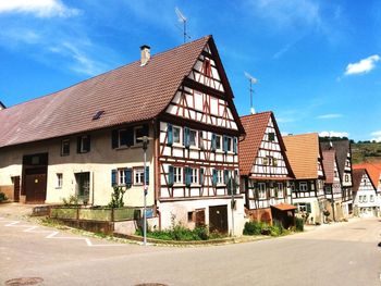 Houses by road against sky in city