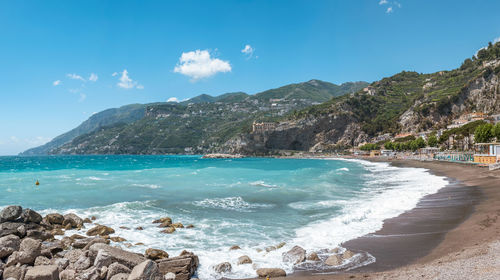 Scenic view of sea and mountains against blue sky